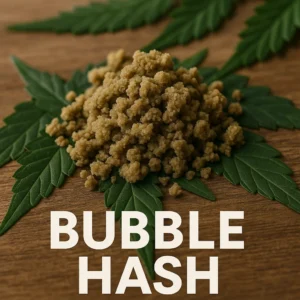 blond bubble hash granules piled on cannabis leaves on a wooden table