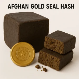 afghan gold seal hash cube with crumbly cut face and a gold star seal coin on white background